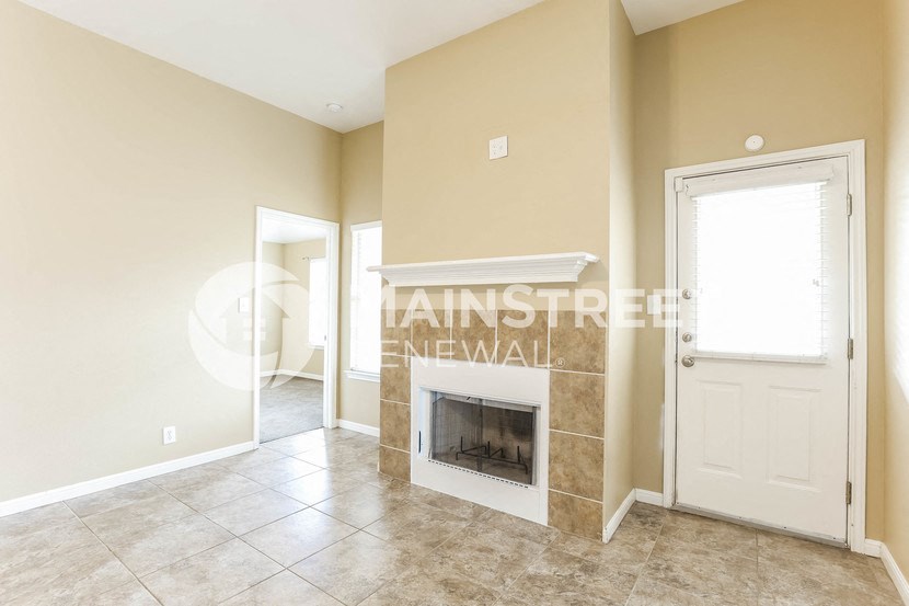 a living room with a fireplace and a white door