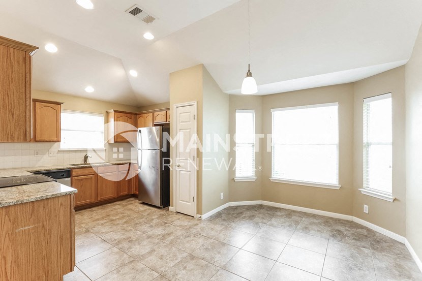 a large kitchen with wood cabinets and stainless steel appliances