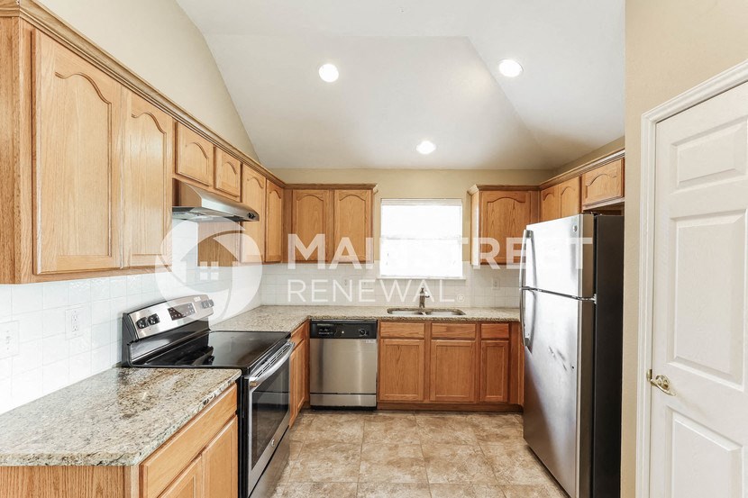 a kitchen with wooden cabinets and stainless steel appliances