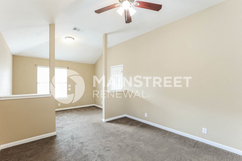 a room with a carpeted floor and a ceiling fan