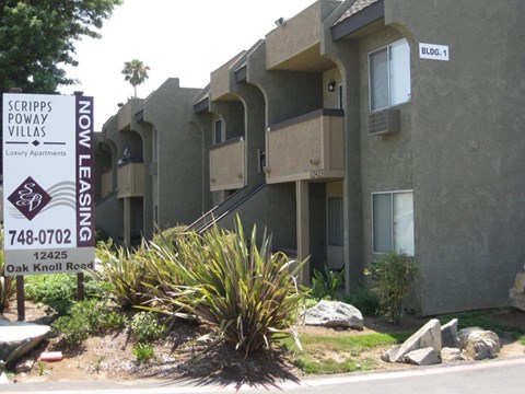 A sign for Scripps Poway Villas is in front of a building.