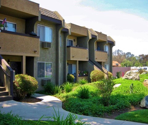 Apartment complex with greenery in front.