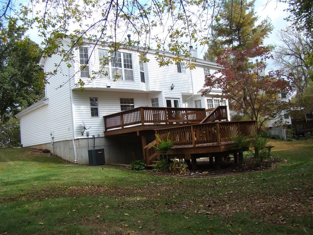 a large white house with a wooden deck
