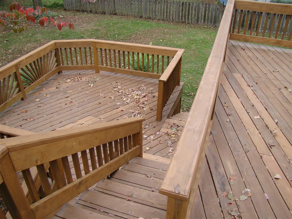 a wooden deck in a backyard with wooden stairs