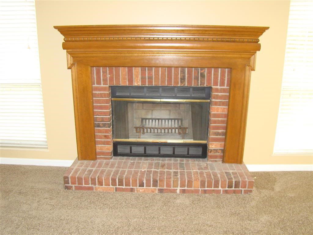 a fireplace in a living room with a wooden mantle