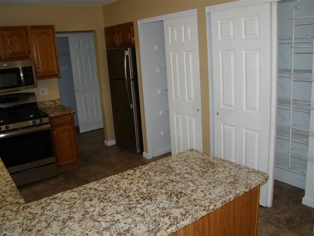 a kitchen with a granite counter top and a refrigerator