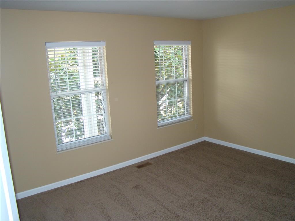 a empty room with two windows and a carpet