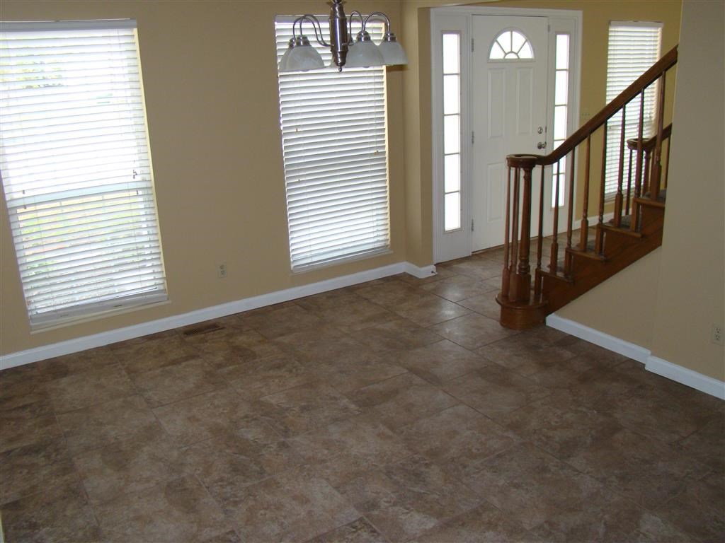 a living room with a staircase and a tile floor