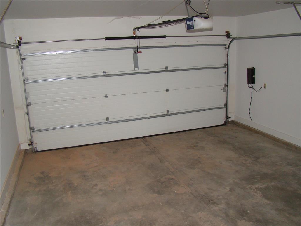 the garage door is closed in a room with a cement floor