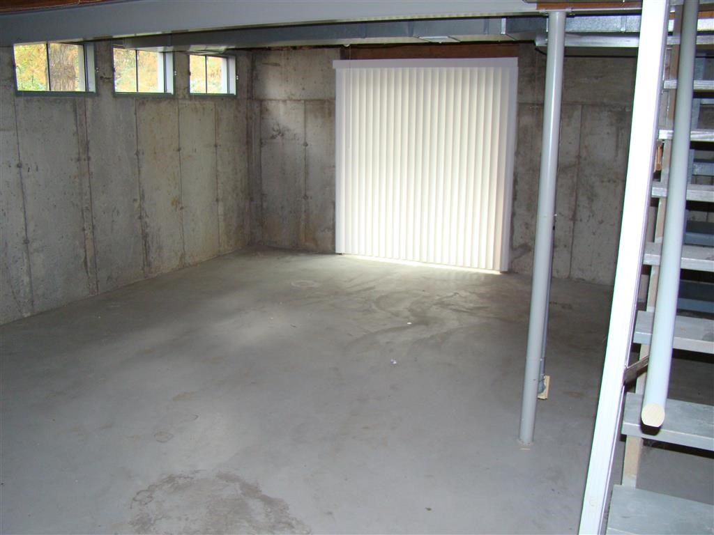 the inside of a garage with a garage door and a ladder