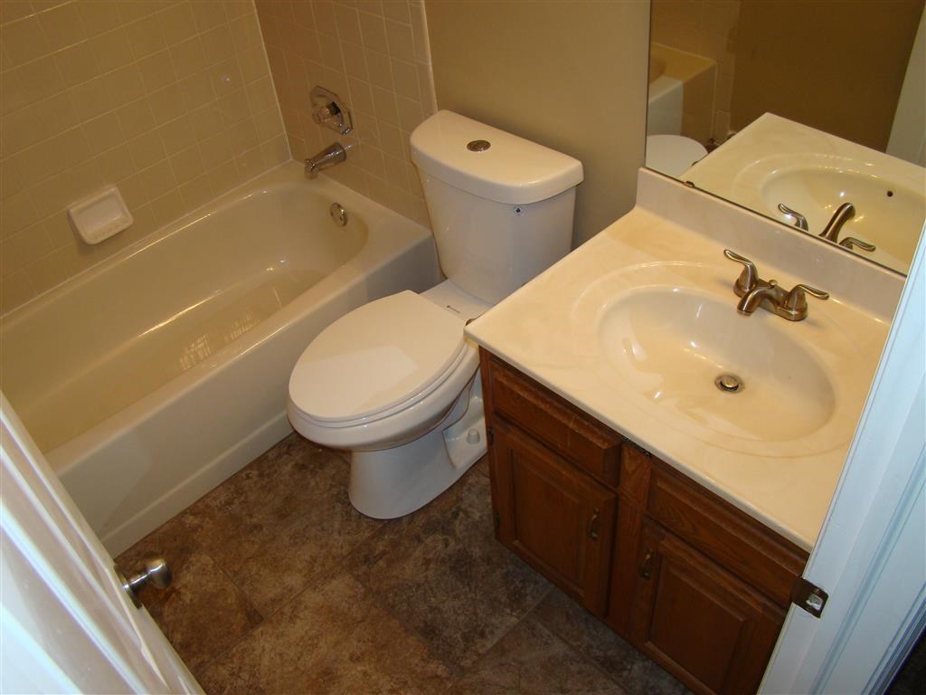a bathroom with a toilet and a tub and a sink