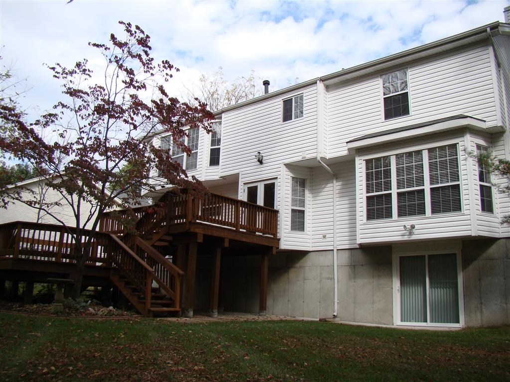 a white house with a wooden deck on the side of it