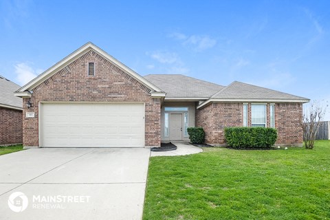 a brick house with a white garage door and a green lawn