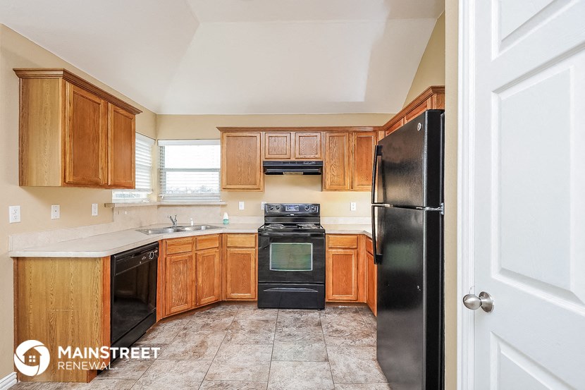 a kitchen with wooden cabinets and black appliances