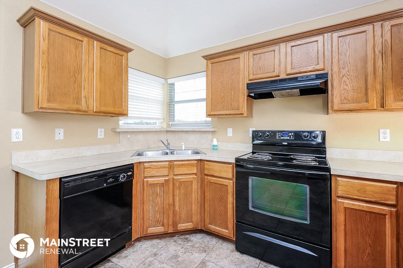 a kitchen with wood cabinets and black appliances and a sink