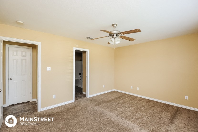 a living room with carpet and a ceiling fan