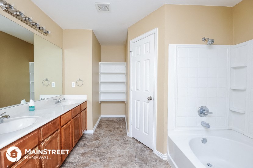 a bathroom with a tub and a sink and a shower and a closet