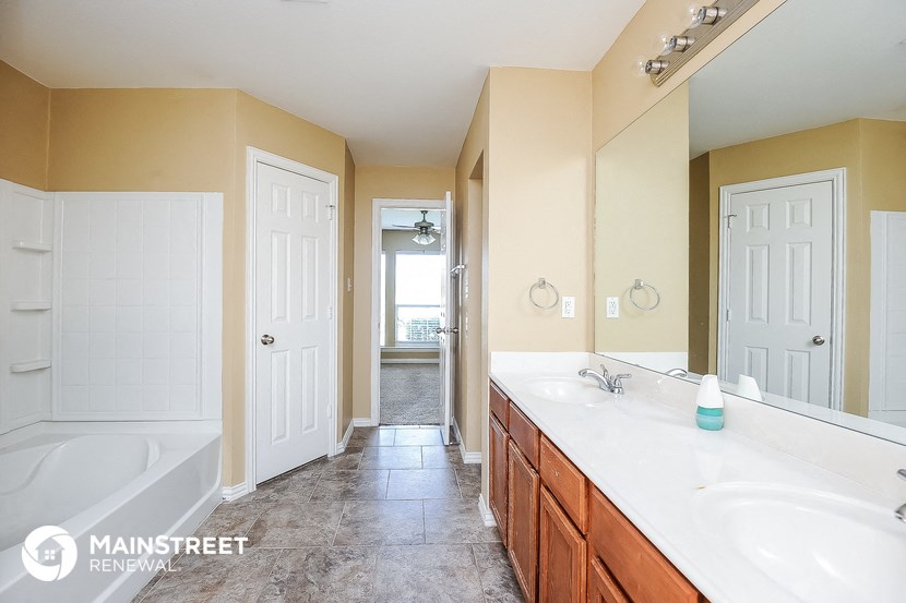 a bathroom with two sinks and a tub and a mirror