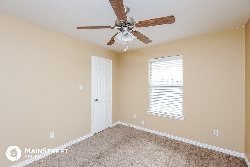 the master bedroom has a ceiling fan and a closet