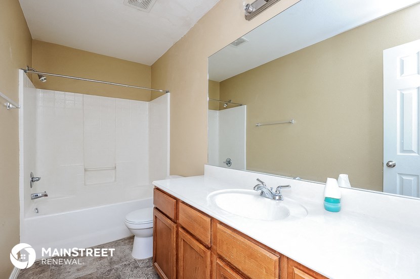 a bathroom with a large mirror and a sink and a toilet