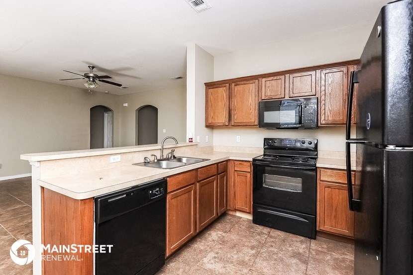 a kitchen with black appliances and wooden cabinets