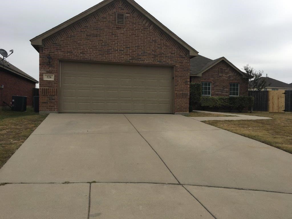 a concrete driveway in front of a house with a garage door