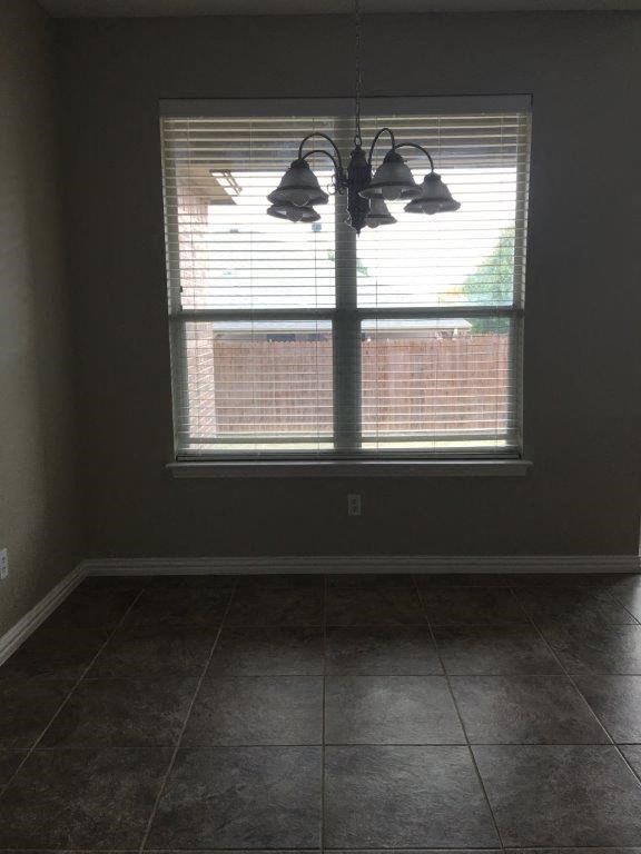 an empty room with a window and a light fixture