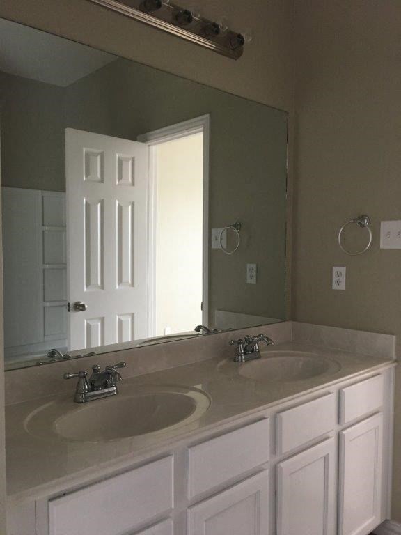 a bathroom with two sinks and a large mirror