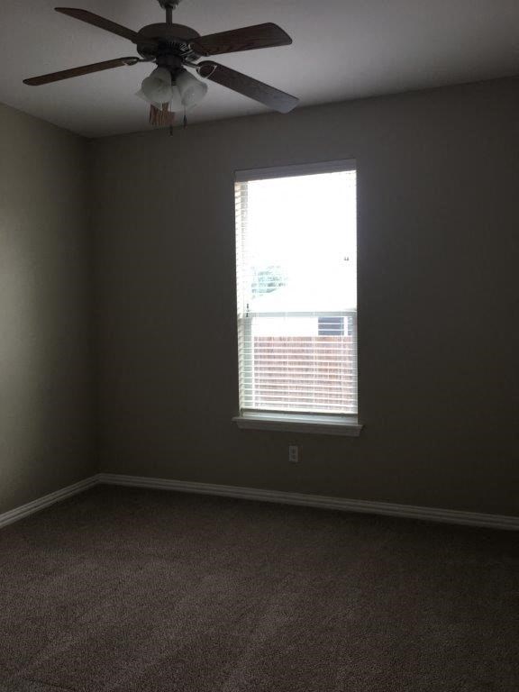a living room with a ceiling fan and a window