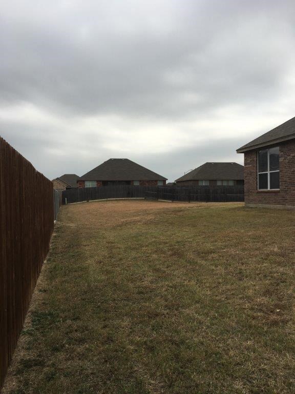 a backyard with a fence and some houses