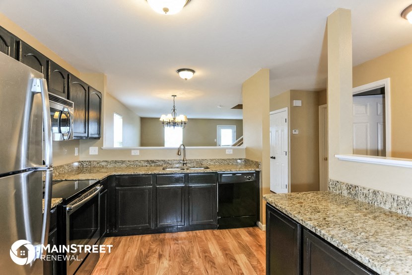 a kitchen with granite counter tops and black appliances