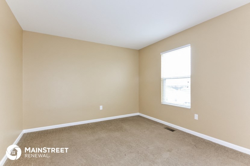the upstairs bedroom with carpet and a window