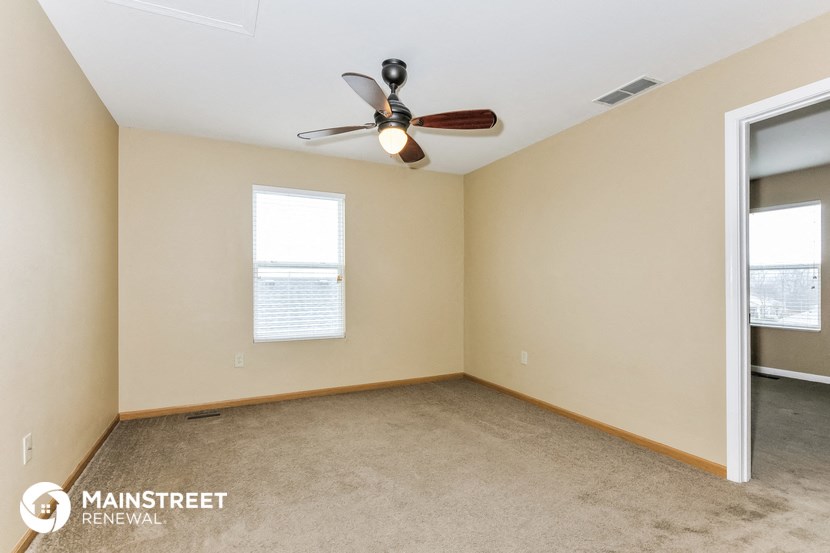 a living room with a ceiling fan and a window