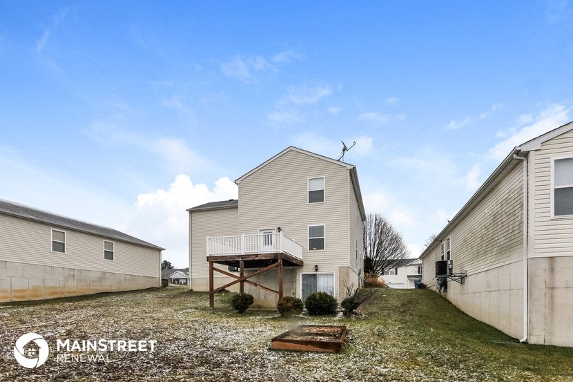 the view of the backyard of a house with a yard and a deck