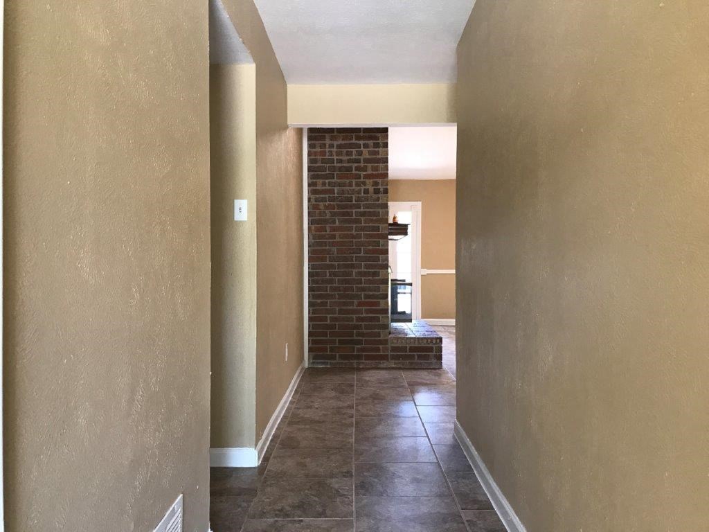 a view of a living room and a kitchen from the hallway