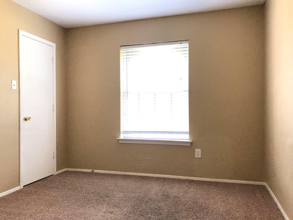 an empty room with a window and a door