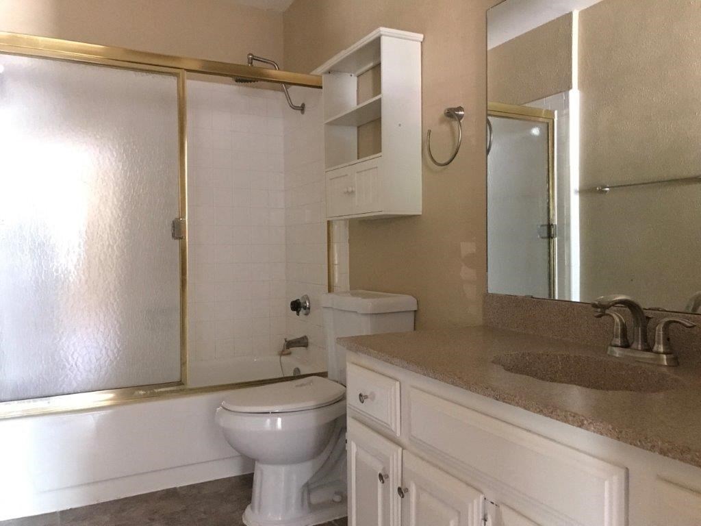 a bathroom with a toilet and a sink and a shower