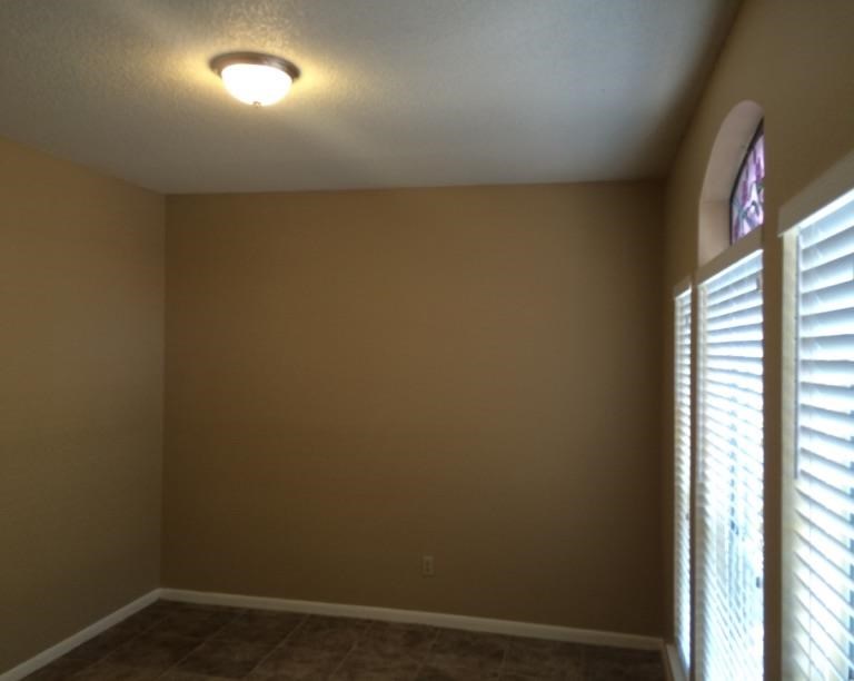 a living room with three windows and a light on the ceiling
