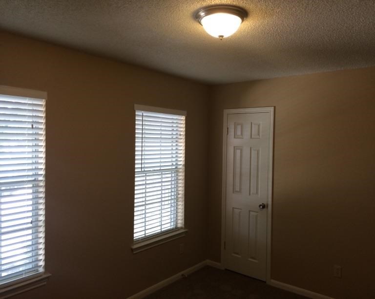 a room with two windows and a white door