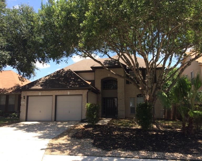 a house with a garage and a tree in front of it