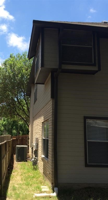 the side of a house with a yard and a fence