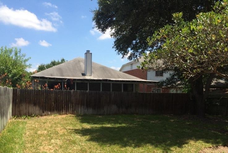 a backyard with a fence and a house