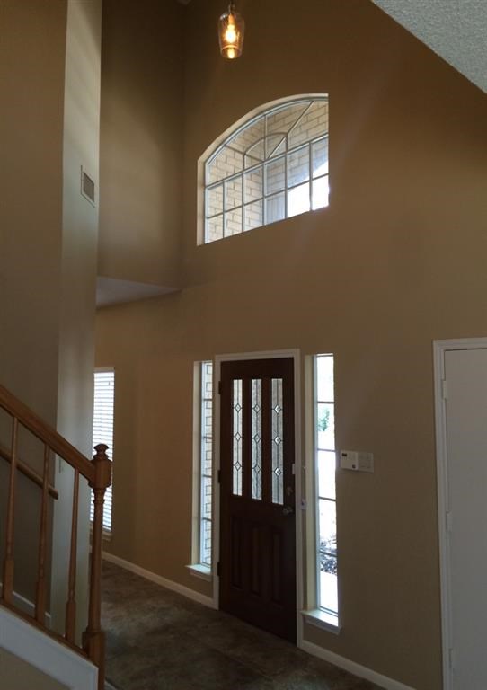 a hallway with a door and a window and a staircase