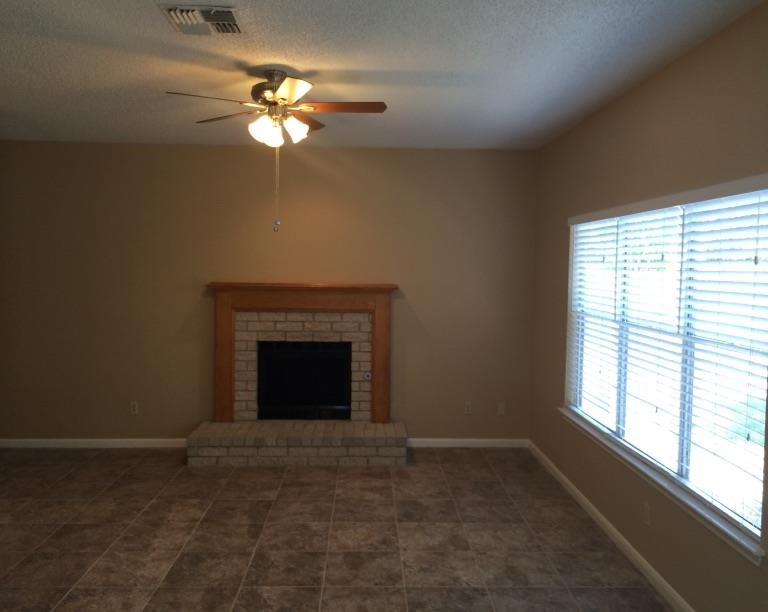 a living room with a fireplace and a ceiling fan