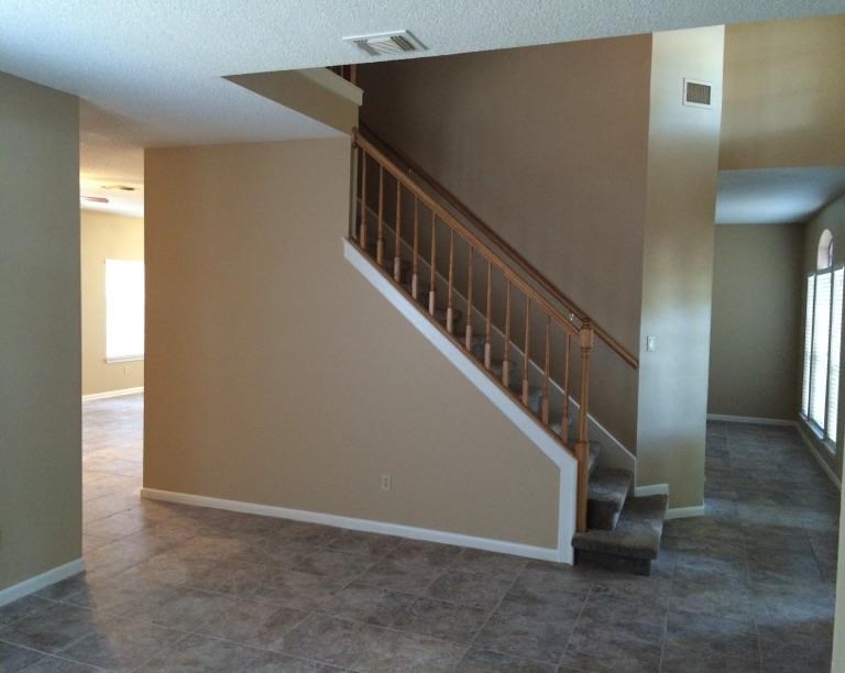 an empty living room with a staircase