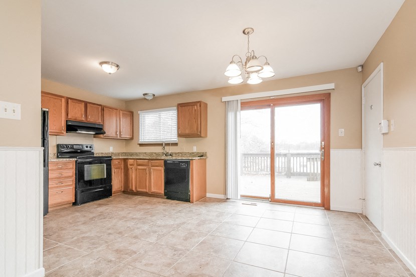 an empty kitchen with a sliding glass door to a patio