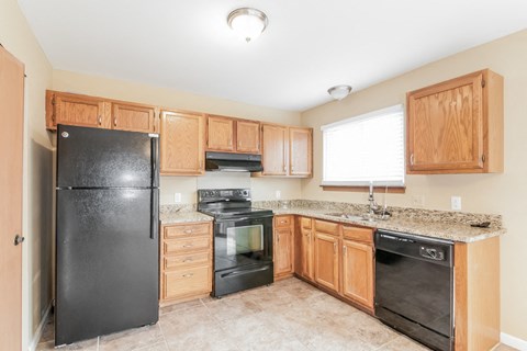 a kitchen with black appliances and wooden cabinets