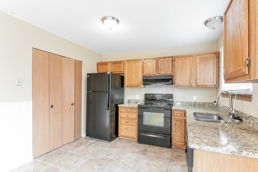a kitchen with black appliances and wooden cabinets