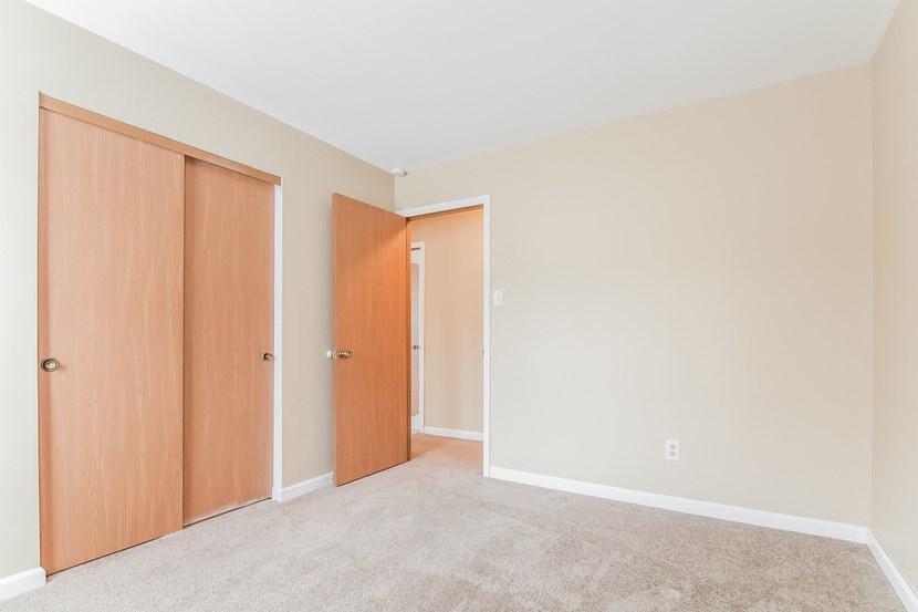 a bedroom with two doors and a carpeted floor