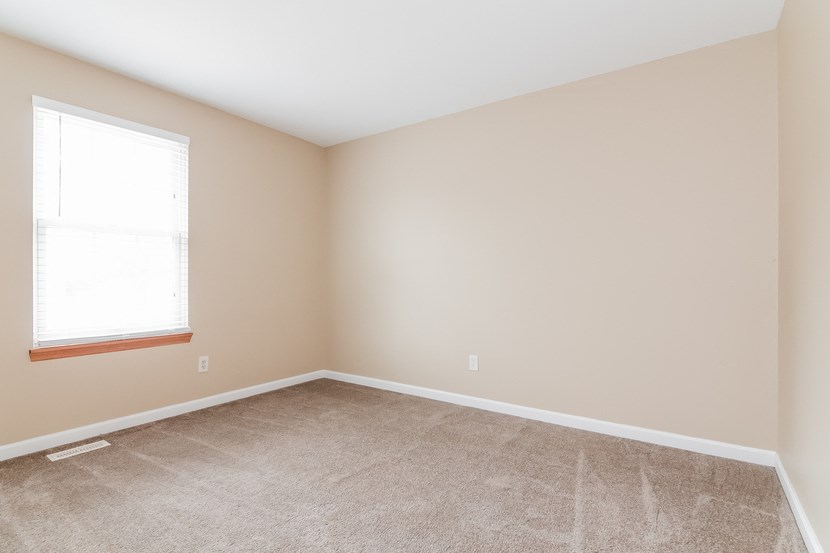 an empty room with carpet and a window